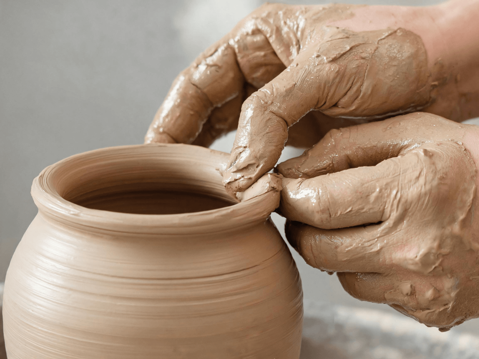 Ceramic maker shaping a vessel by hand
